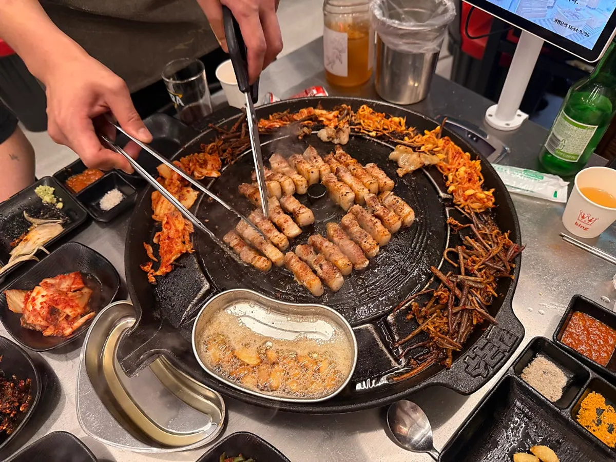 Pork belly cooking on the iron-lid griddle
