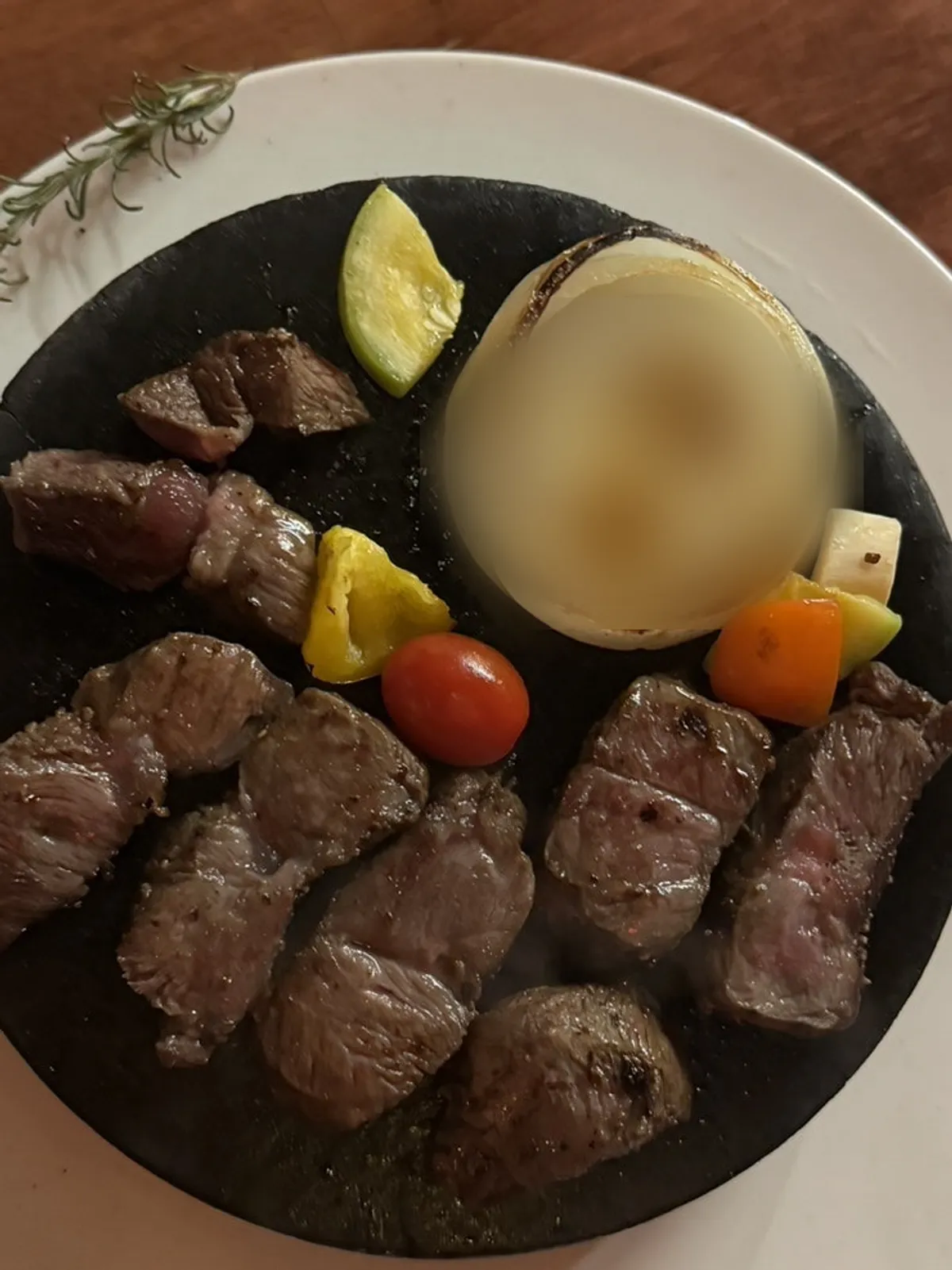 Steak and grilled vegetable garnish on the stone plate