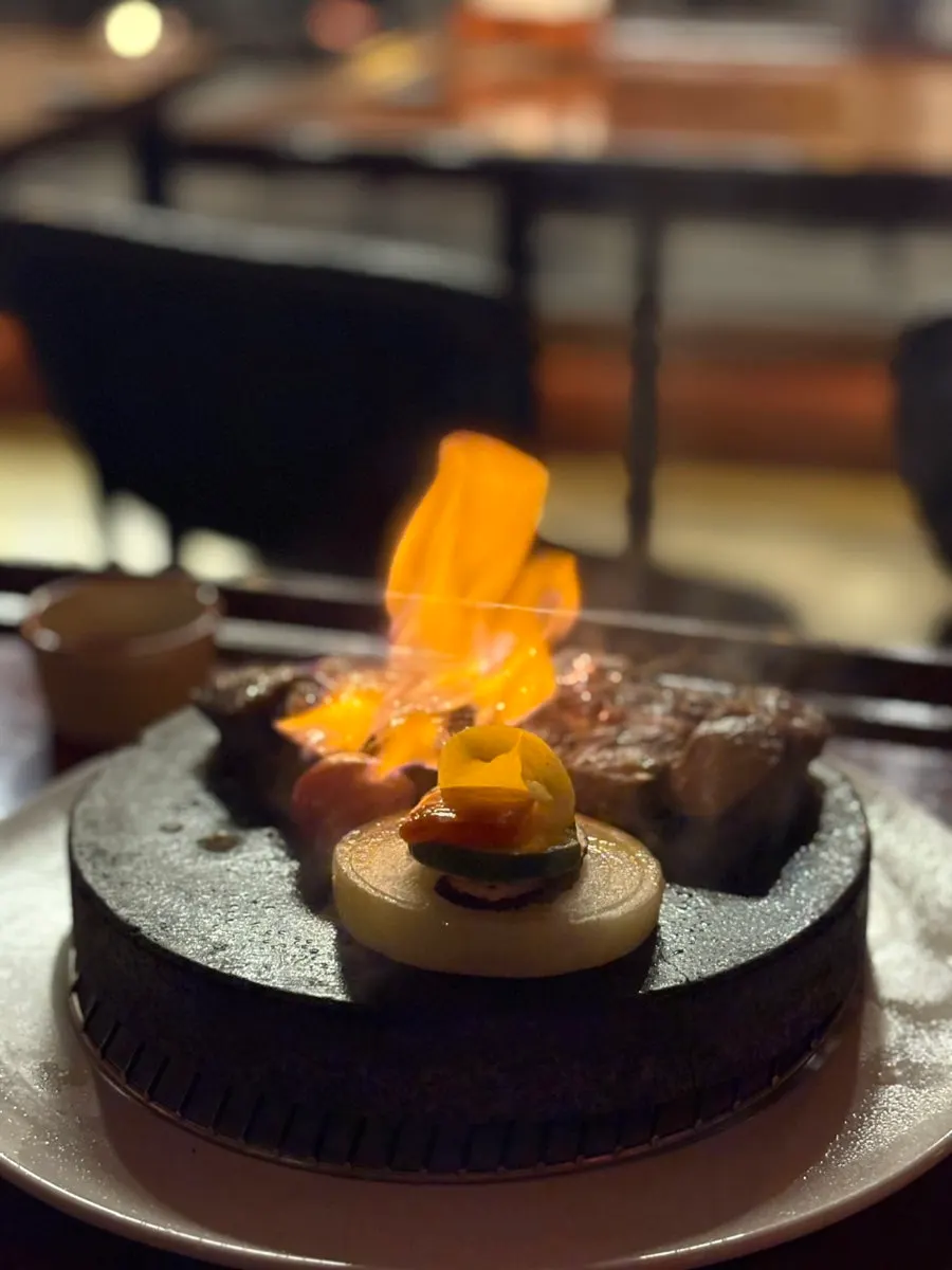 Stone steak cooking on a hot stone plate