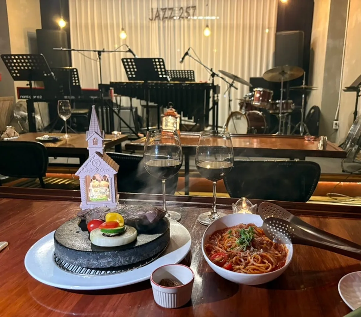 A table set with both the steak and the seafood tomato pasta