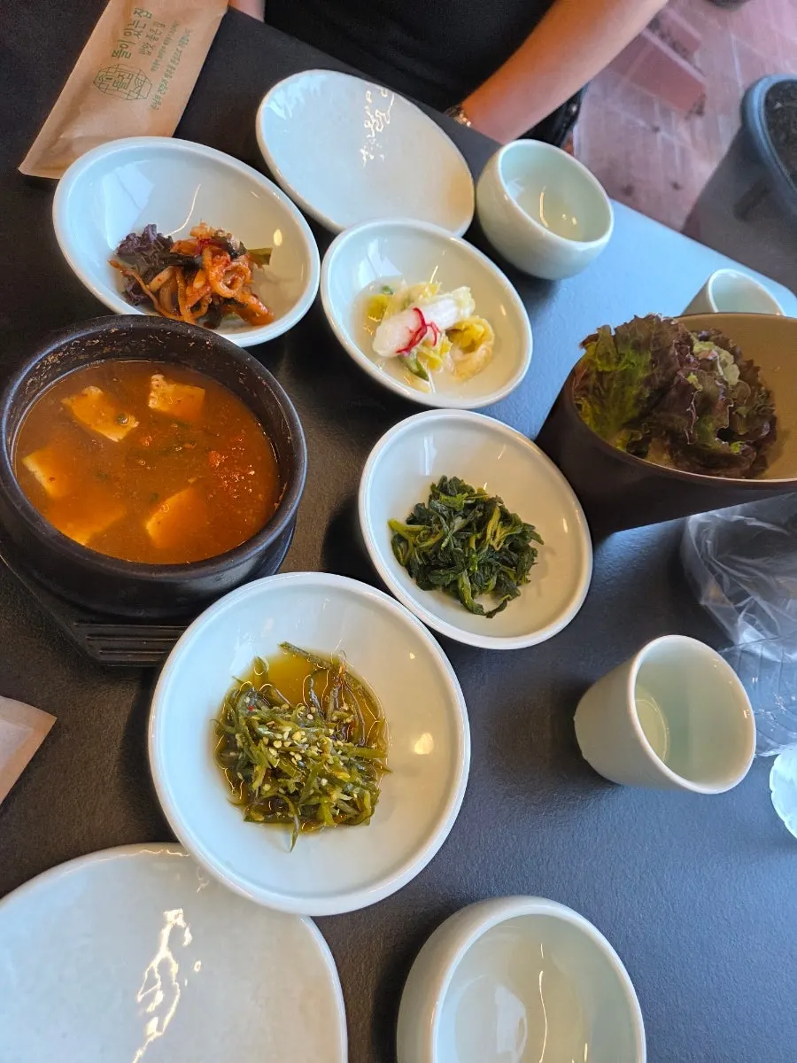 사기 그릇과 종이 포장 수저가 놓인 테이블 세팅