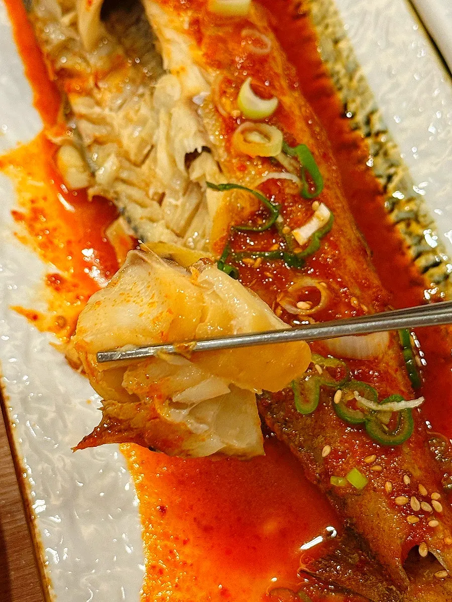 A bite of braised codfish with well-balanced seasoning