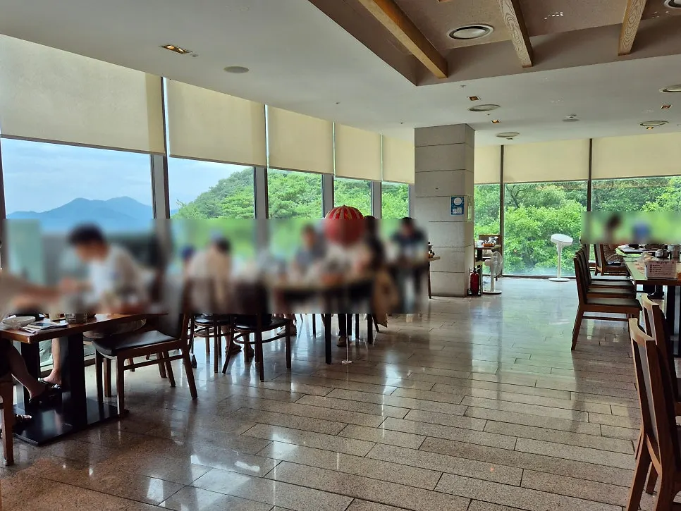 Interior of Deulbabae with floor-to-ceiling forest-view windows