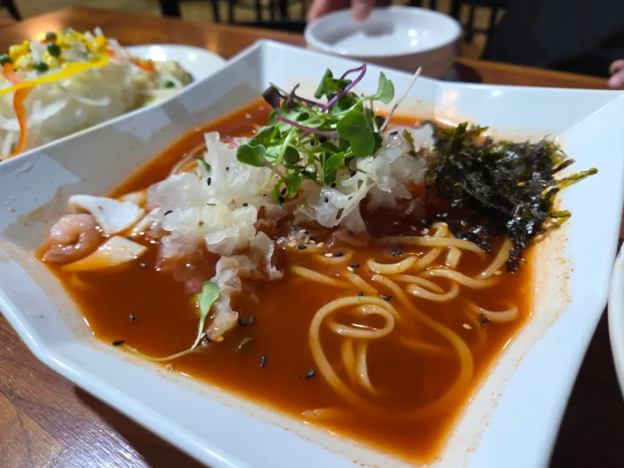 Cold jjamppong topped with shrimp, wood ear mushrooms, and gim flakes