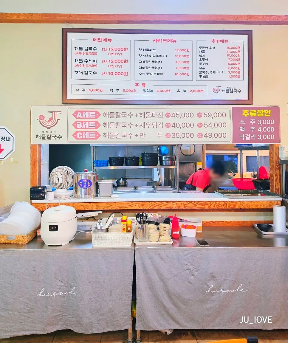 Menu board listing seafood kalguksu and set menus