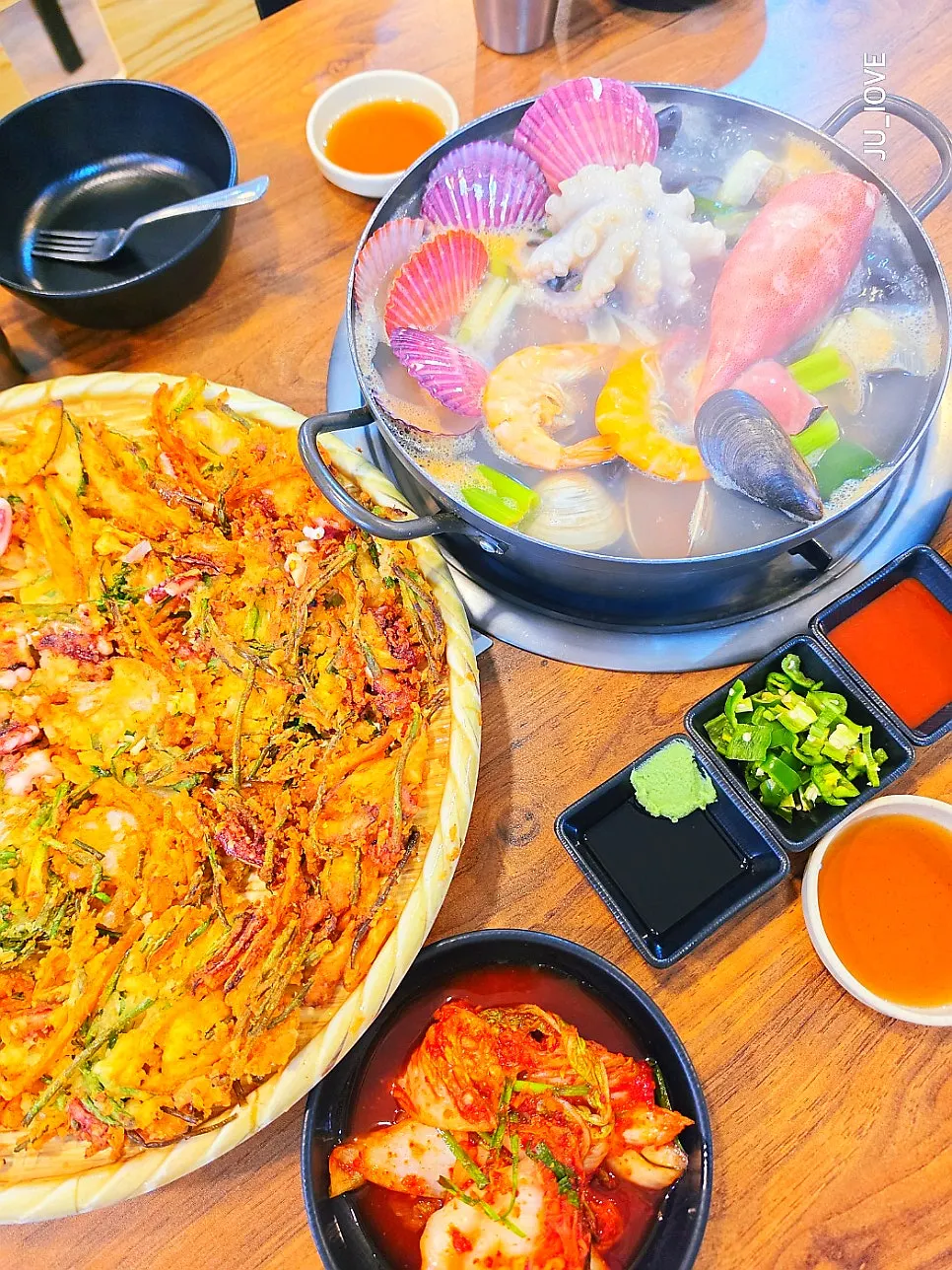 Seafood kalguksu pot with large chunks of green onion