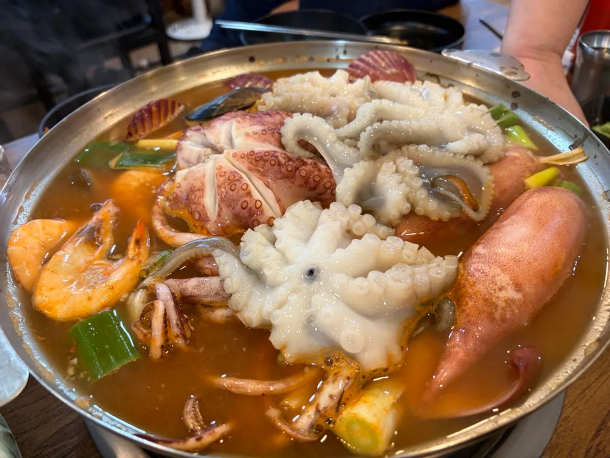 Pot of Jedam Kalguksu's spicy seafood kalguksu loaded with seafood