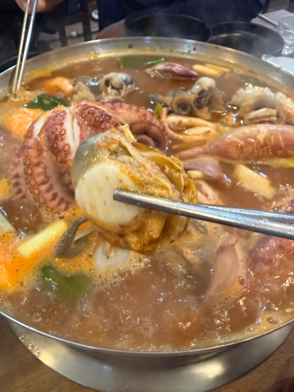 Bowl of seafood kalguksu with squid, mussels, clams and scallops fished out