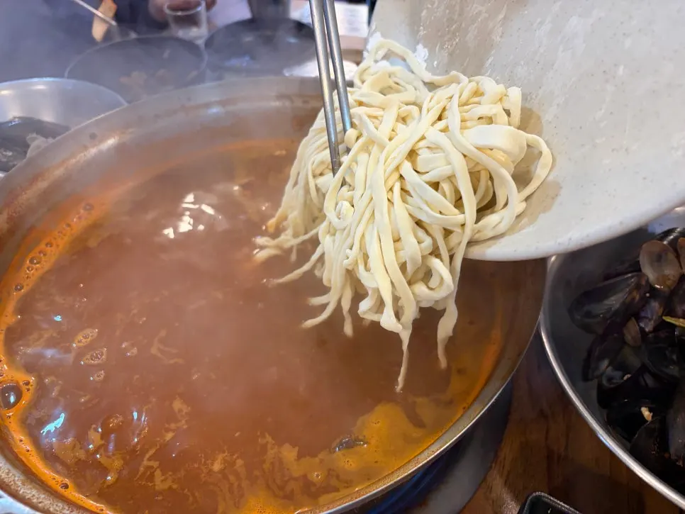 Kalguksu noodles and dumpling added after finishing the seafood