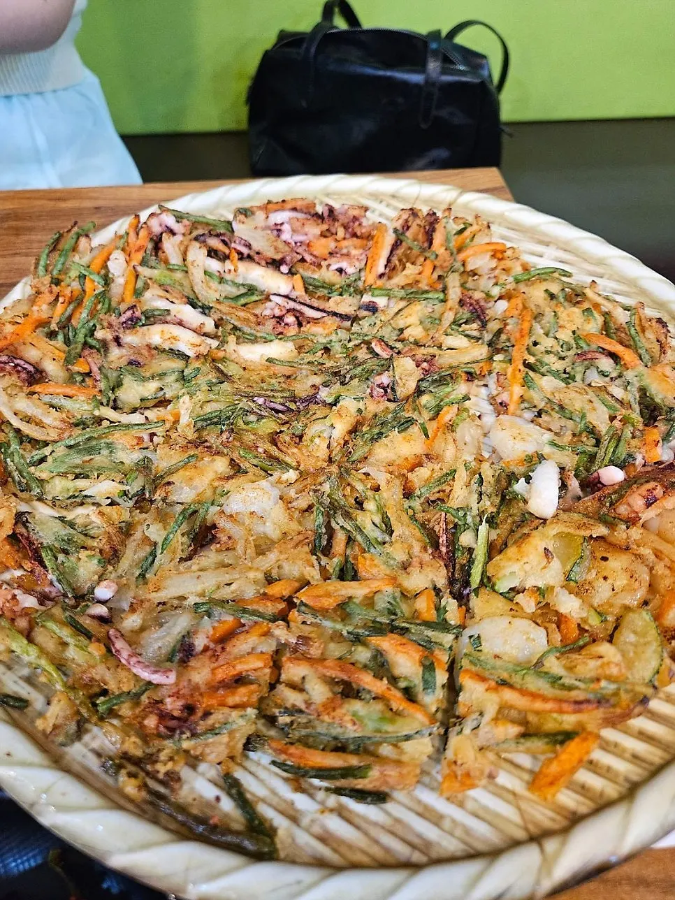Giant seafood pancake filling the entire serving tray