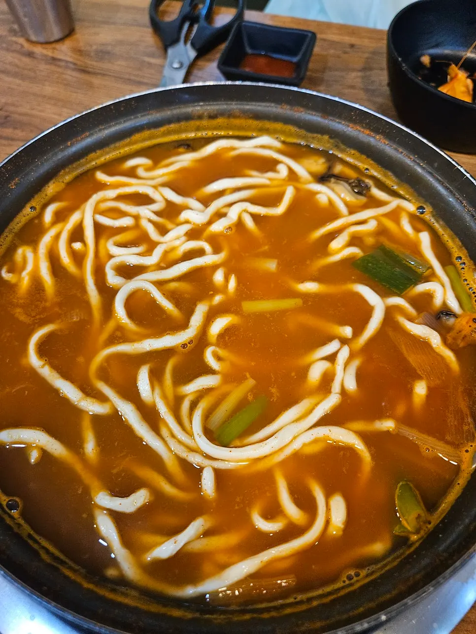 Finished bowl of spicy seafood hand-cut noodle soup with noodles added