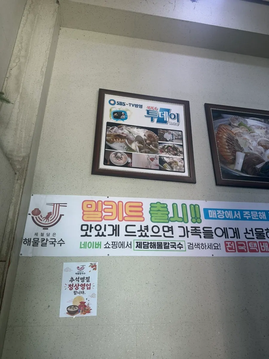 Menu board listing seafood kalguksu and side dishes
