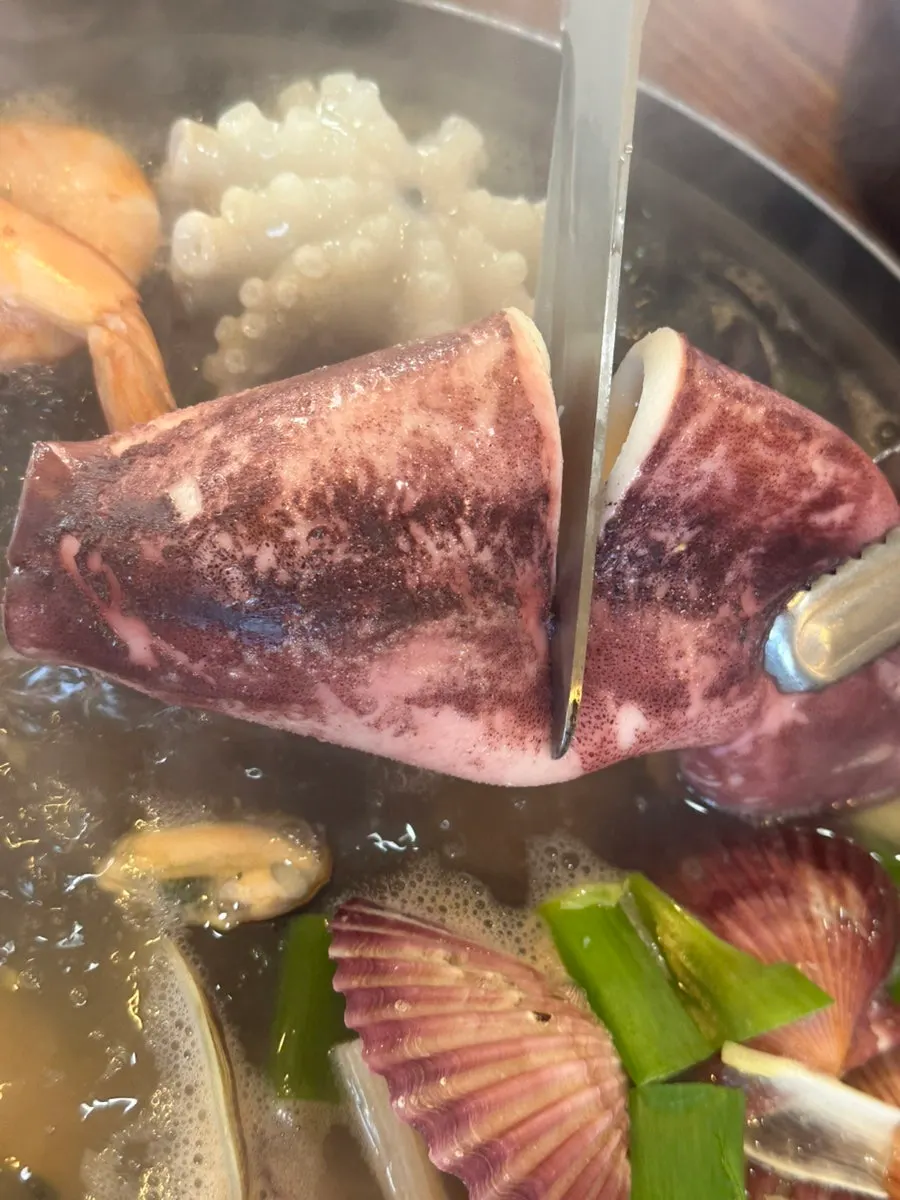 Clear seafood broth with whole squid and octopus