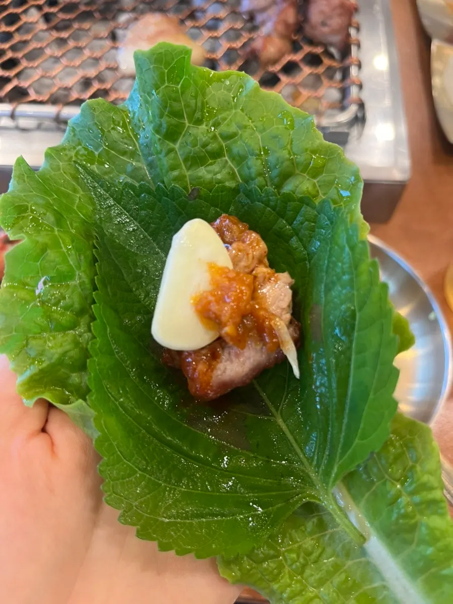 상추에 깻잎과 마늘을 올린 흑돼지 쌈