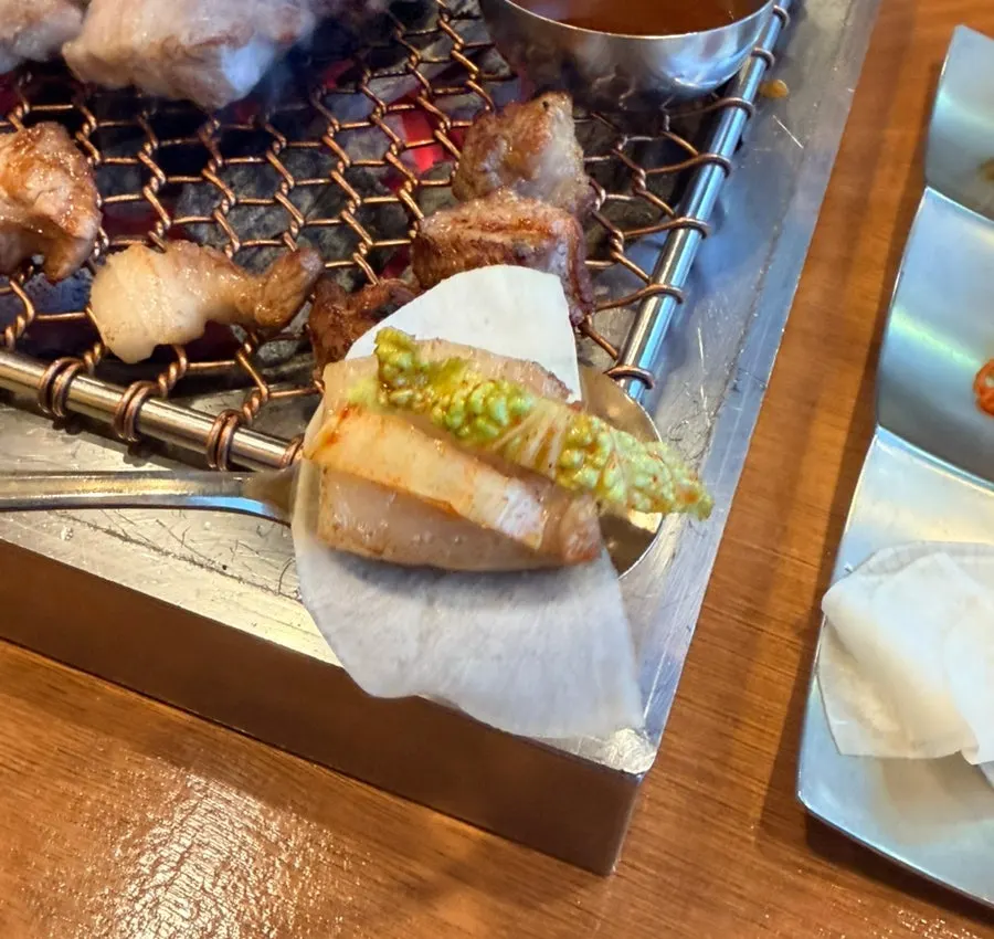 무절임과 겉절이를 올린 흑돼지 한 점