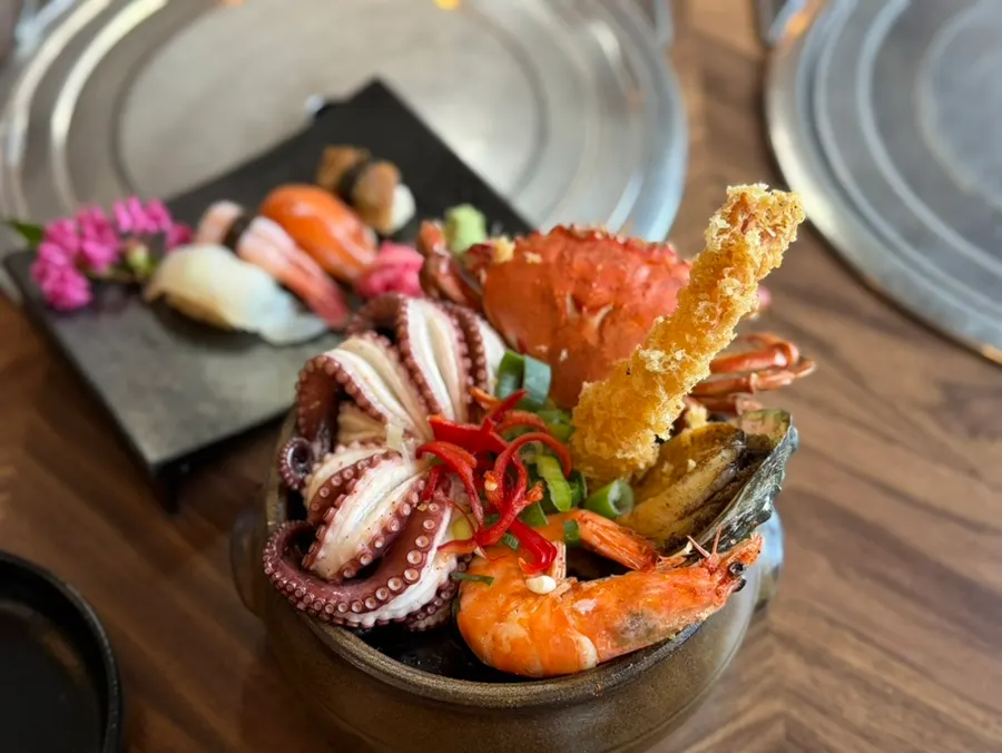 Jar topped with boiled octopus, blue crab, fried shrimp, and abalone