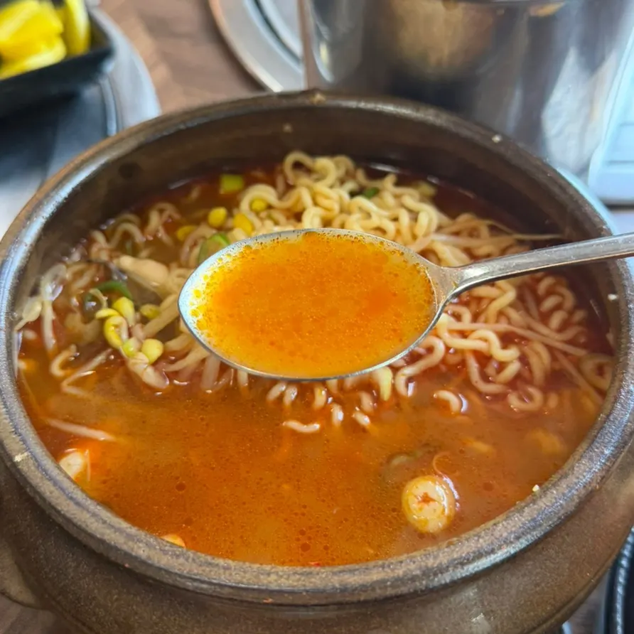 Noodles lifted out of the spicy broth
