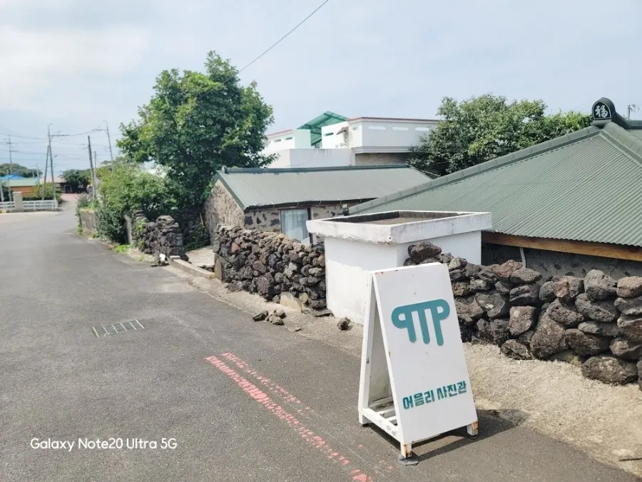 Stone-wall entrance of Eoeum-ri Photo Studio with a classic travel suitcase