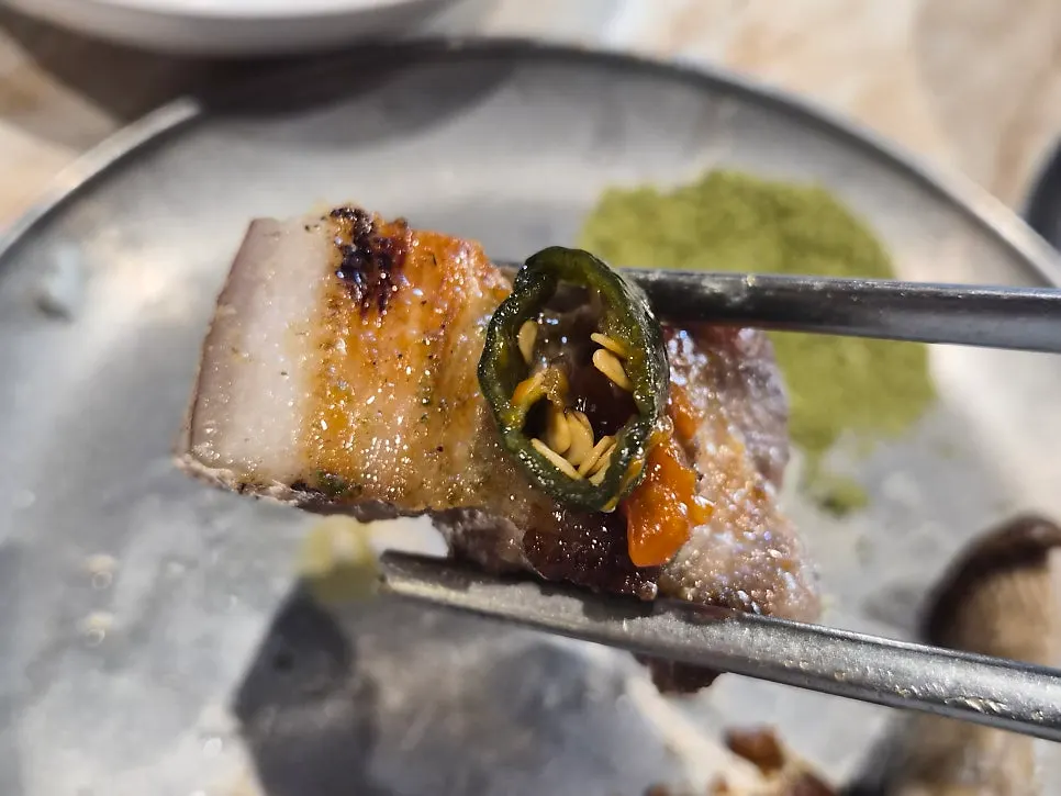 A piece of black pork eaten with pickles