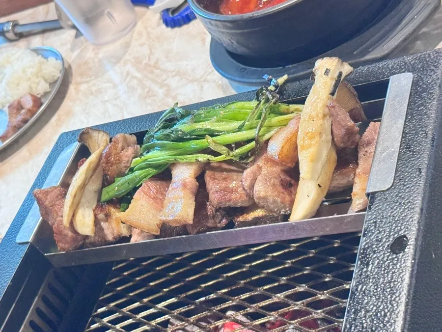 Staff grilling thick cuts of black pork