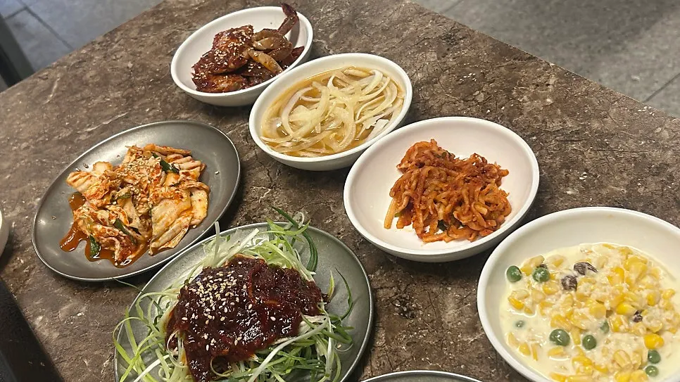 Side dish spread including soy marinated crab and yeolmu kimchi