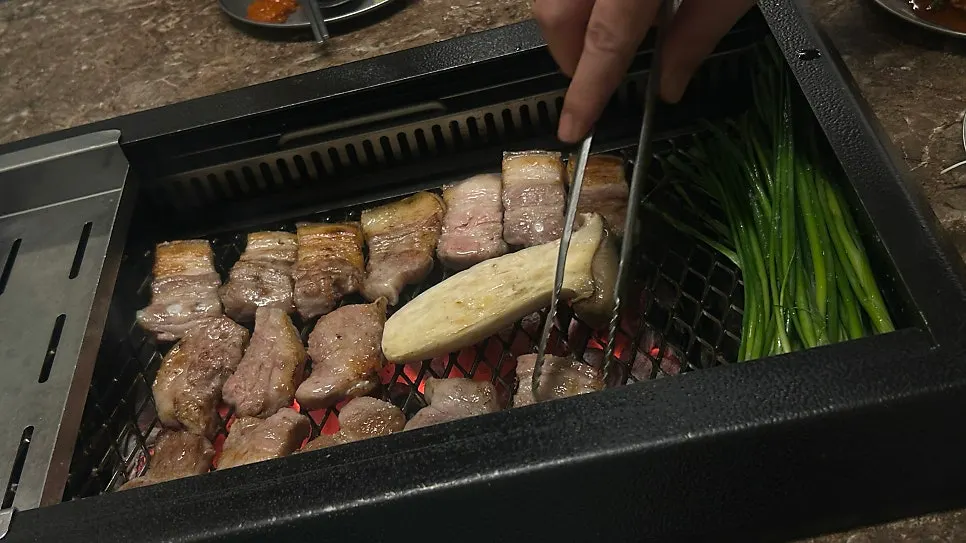 Thick-cut black pork grilling over charcoal
