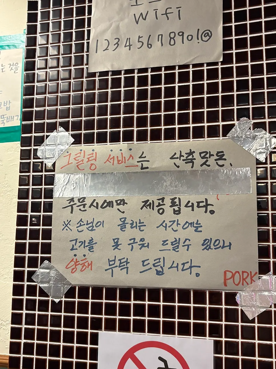 Wall sign at Pork80 noting that staff grill the black pork for guests