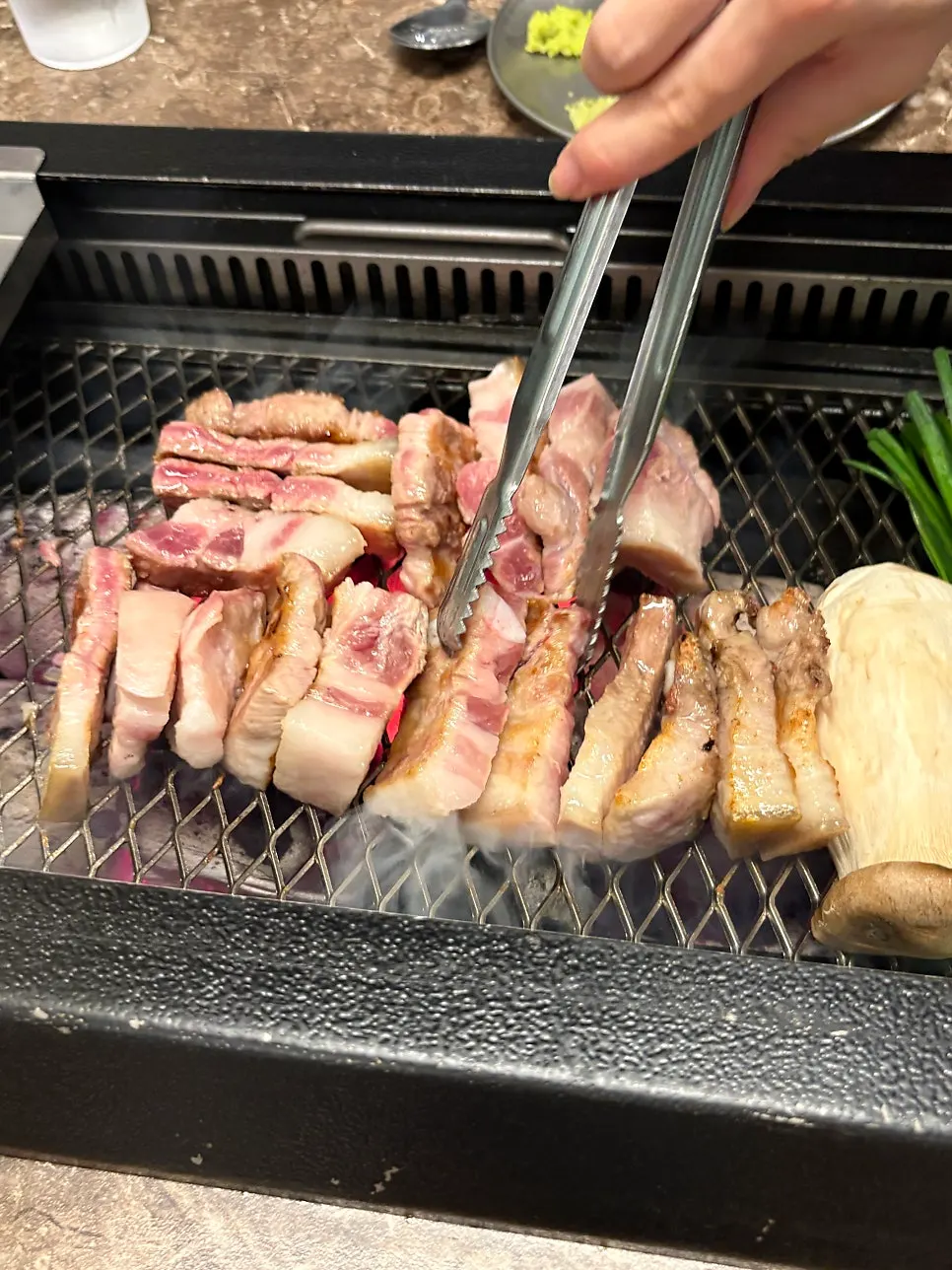 A full round of black pork grilling over charcoal