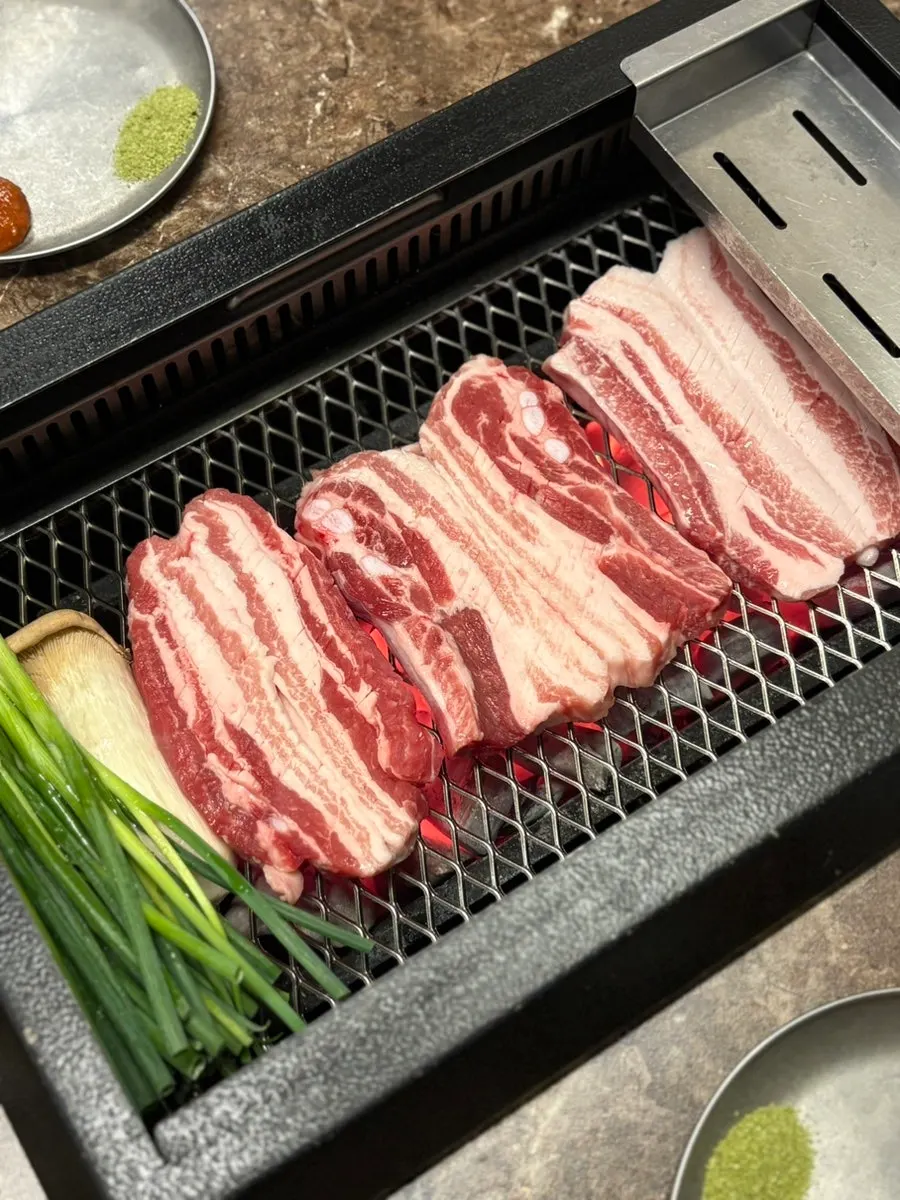 Raw ribs and mushrooms cooking over charcoal