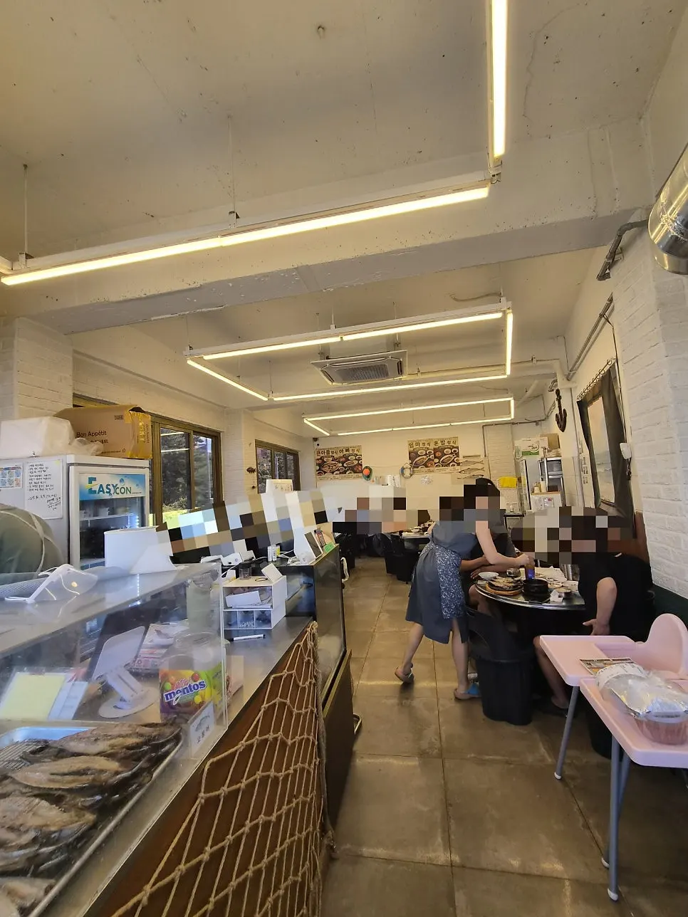 Interior of the grilled fish restaurant busy with customers at 1pm on a weekday