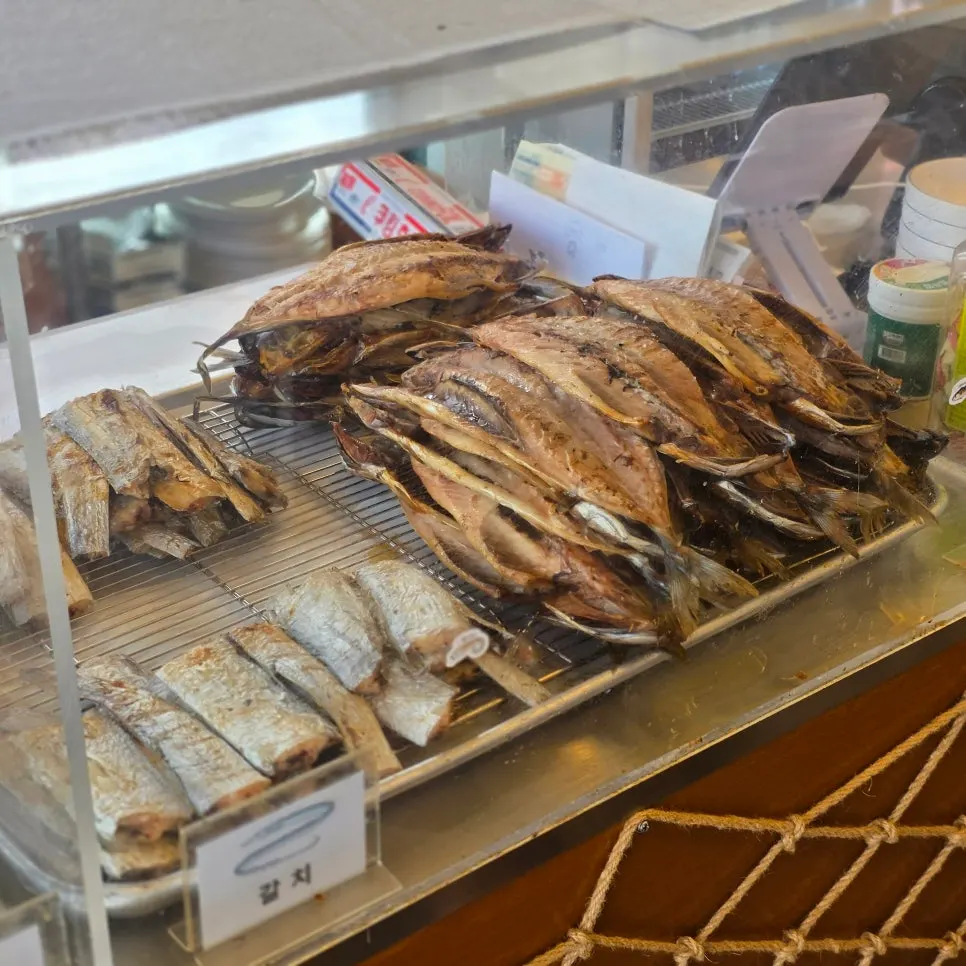 벽돌 느낌 외관과 간판, 메뉴판이 붙은 식당 입구