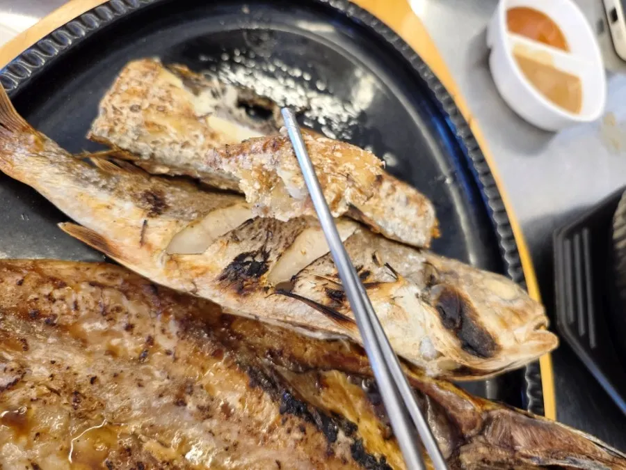 먹기 시작한 생선구이 접시