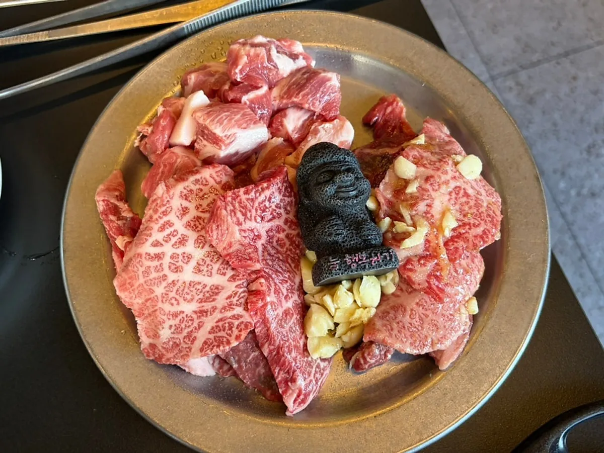 Table spread of hanwoo galbi, garlic galbi, and black pork cubed pork jowl