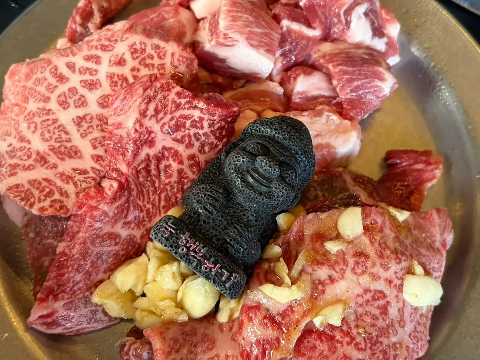 Plate of raw meat topped with a small dolhareubang stone