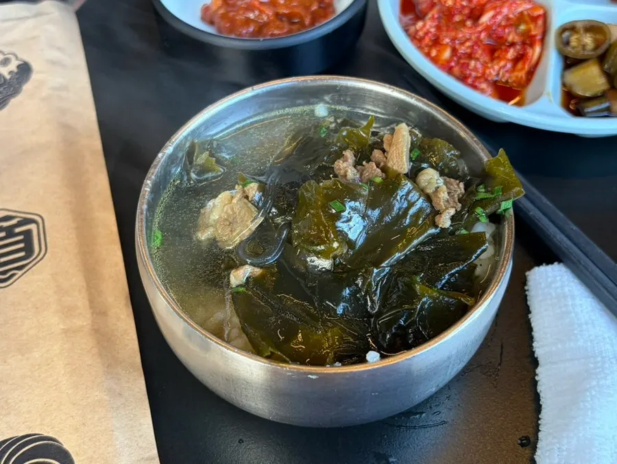Table with seaweed soup and a bowl of rice