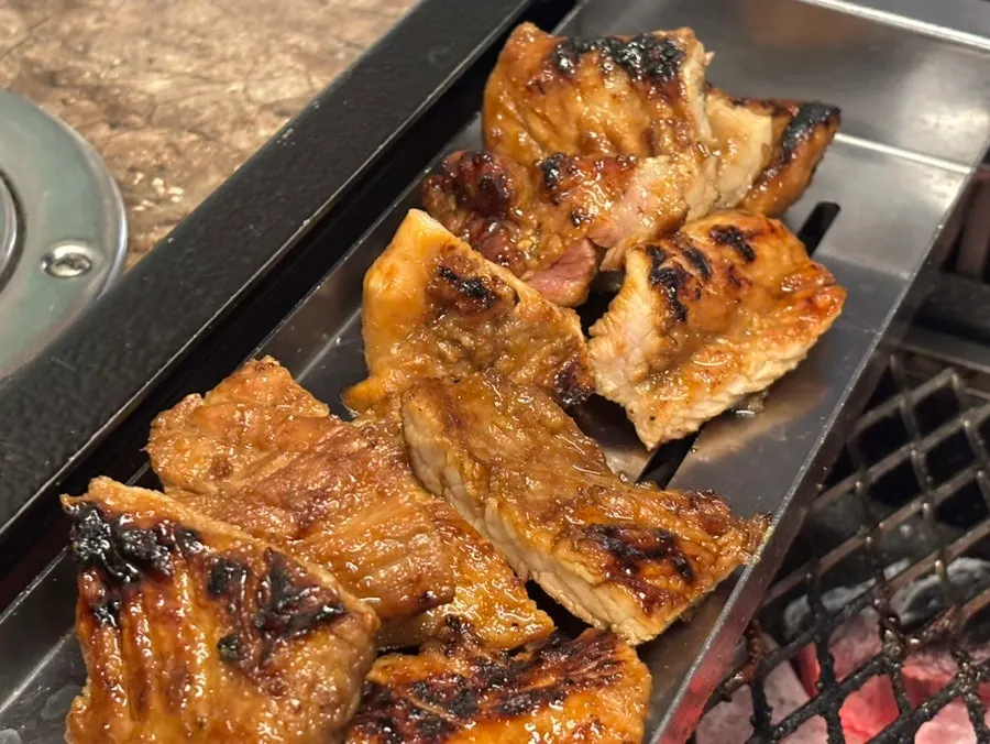 Marinated Jeju pork ribs grilling over charcoal