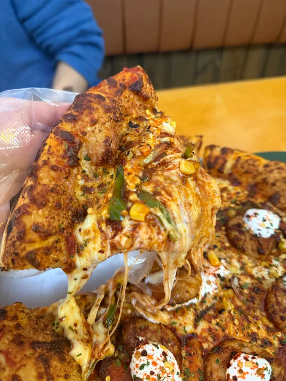 Pizza slice topped with whole shrimp and sour cream sauce