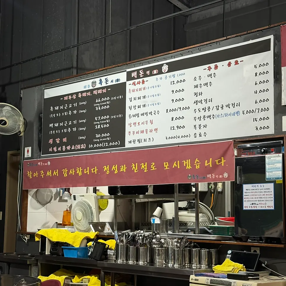 Menu board showing meat and meal options at Heukdonsibaekdonmyeon Shinhwa World Branch