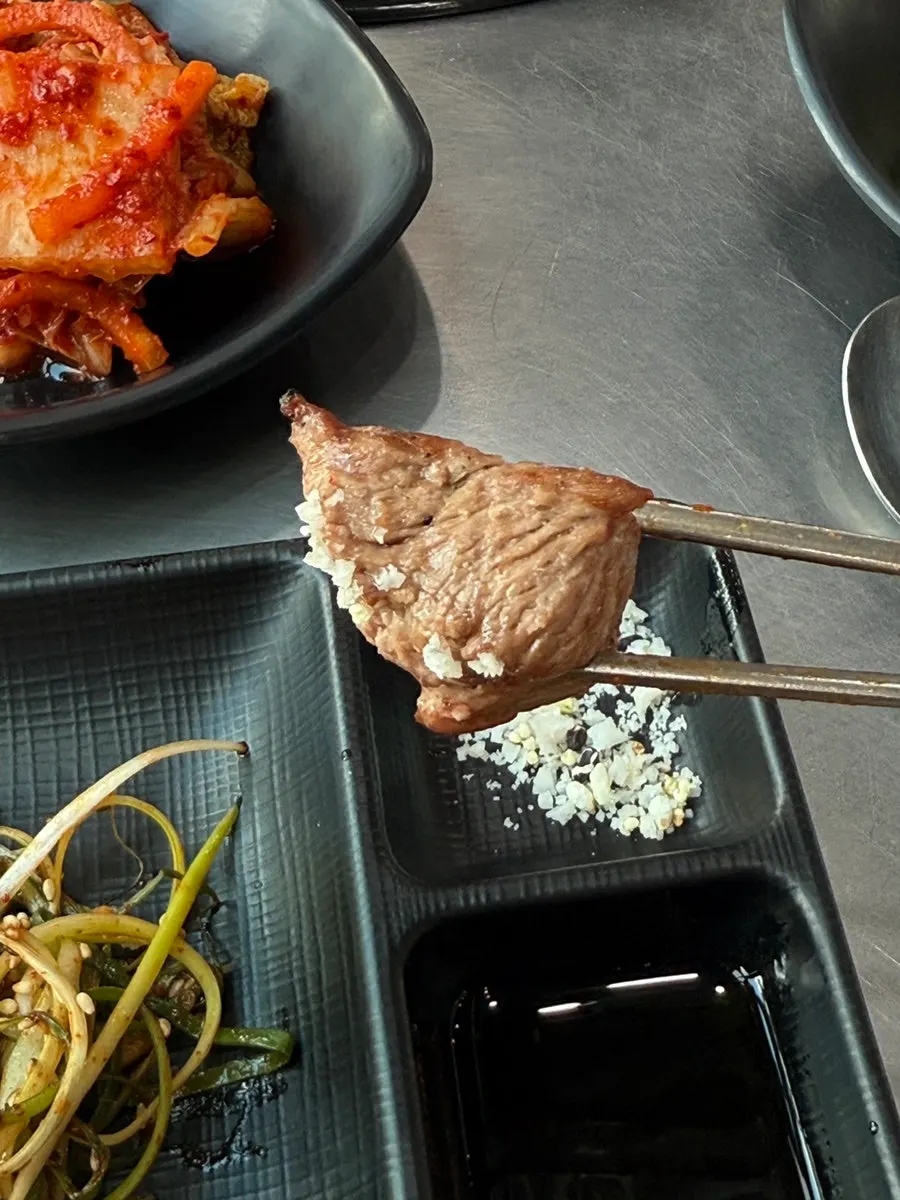 First bite of pork neck dipped in salt