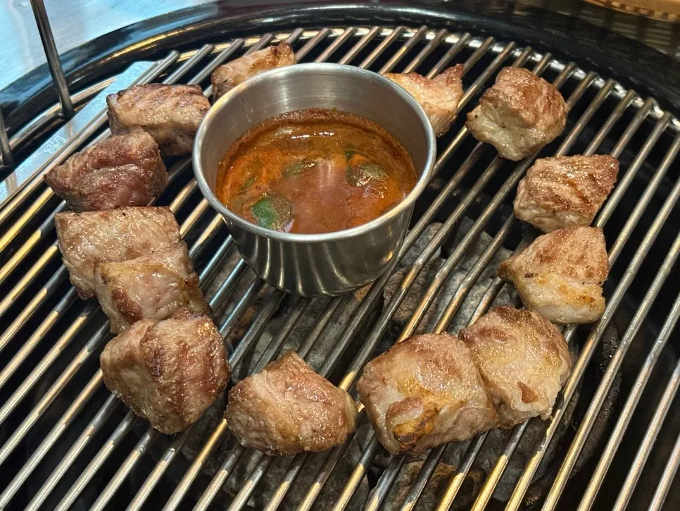 A piece of black pork dipped in wasabi and salt