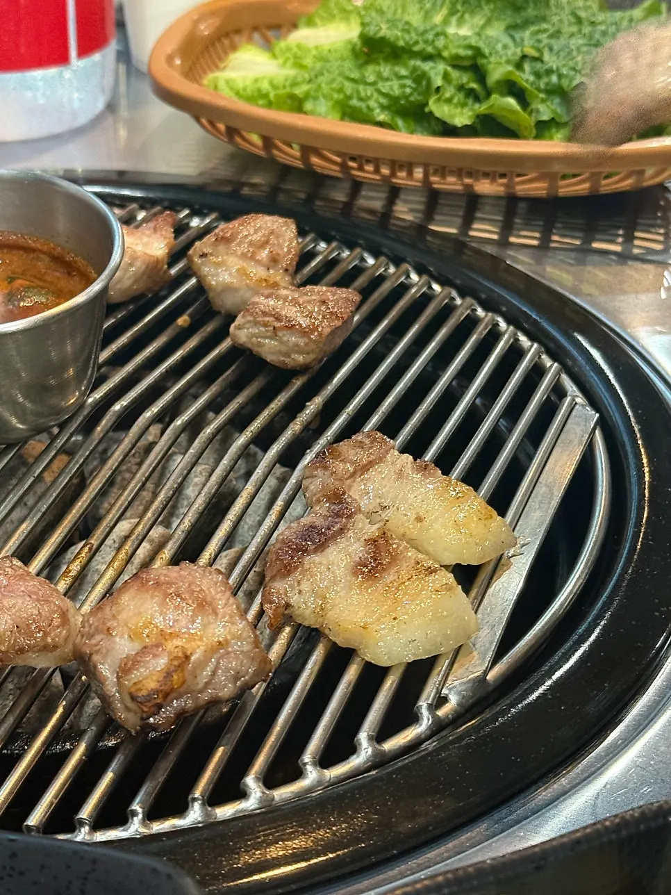 A bite of black pork with perilla leaf and scallion salad