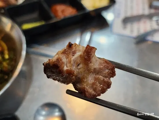 Pre-grilled black pork neck meat placed on the elvan stone grill