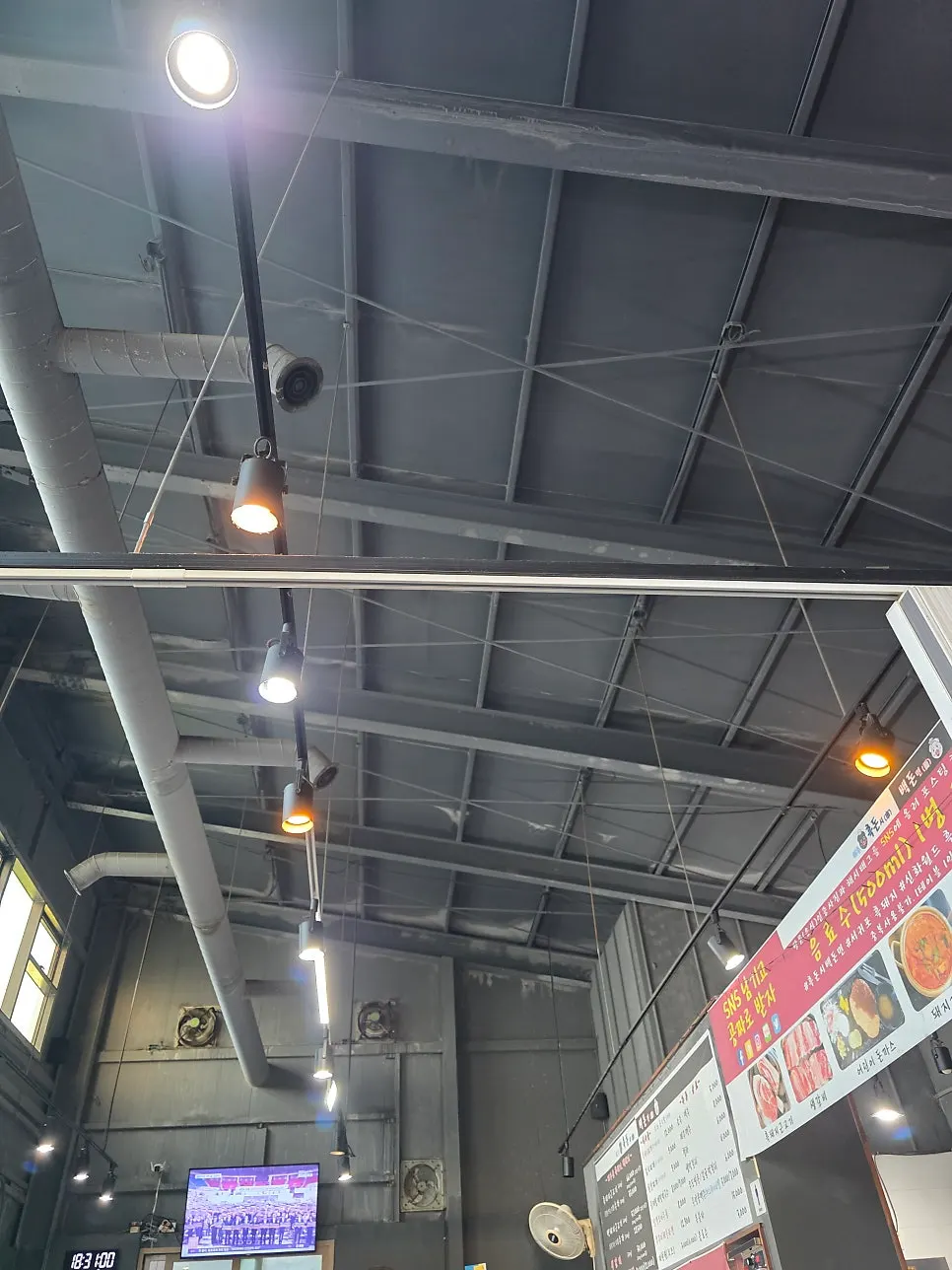 High-ceilinged interior of the black pork restaurant with round briquette tables