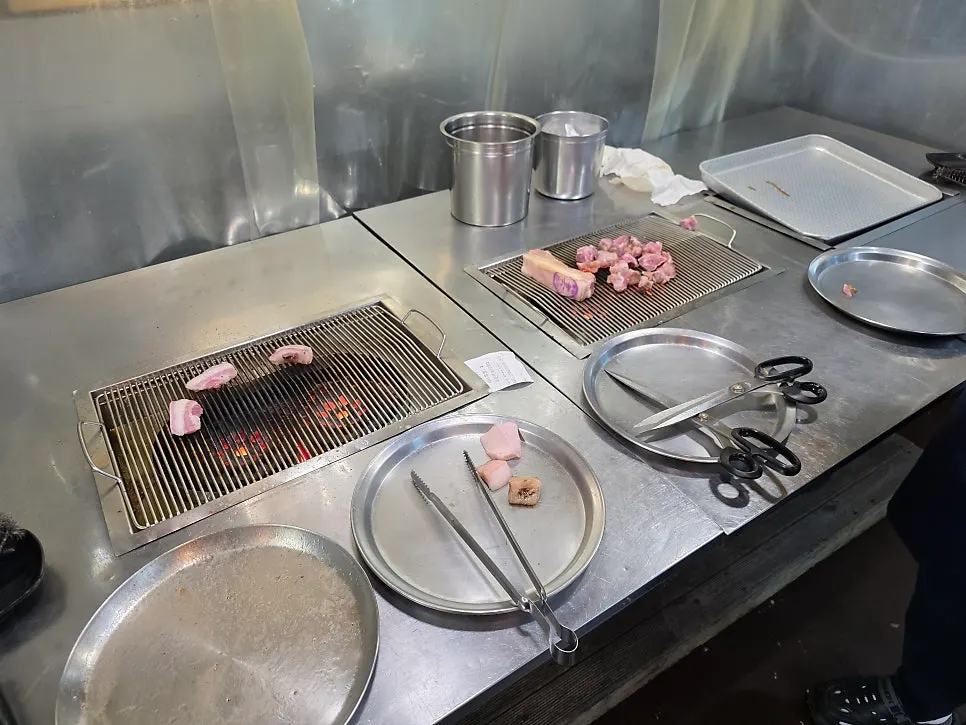 Black pork geungogi being pre-grilled over briquettes