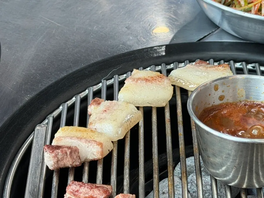 A piece of black pork neck dipped in meoljeot