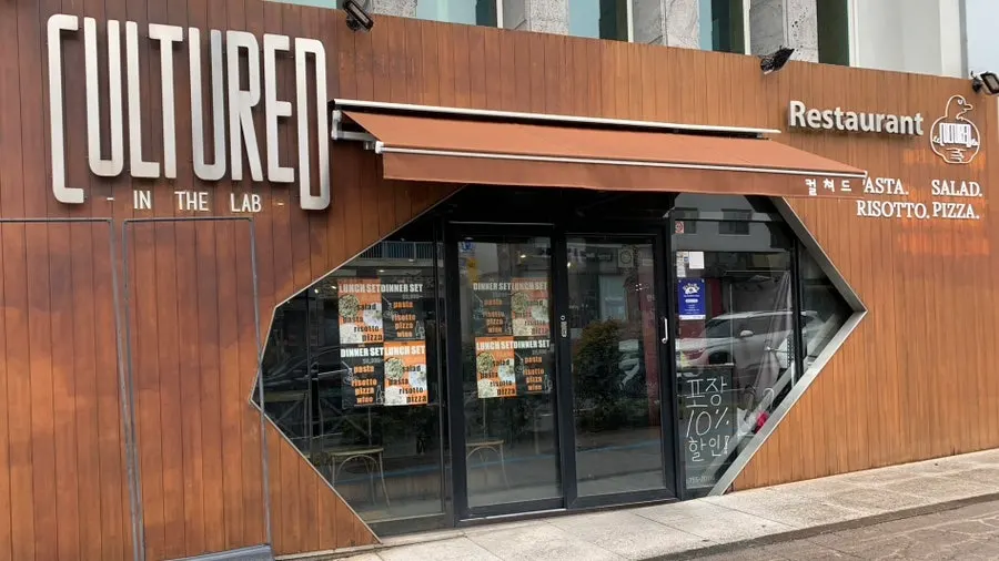 목재와 스텐 간판이 달린 컬쳐드 외관