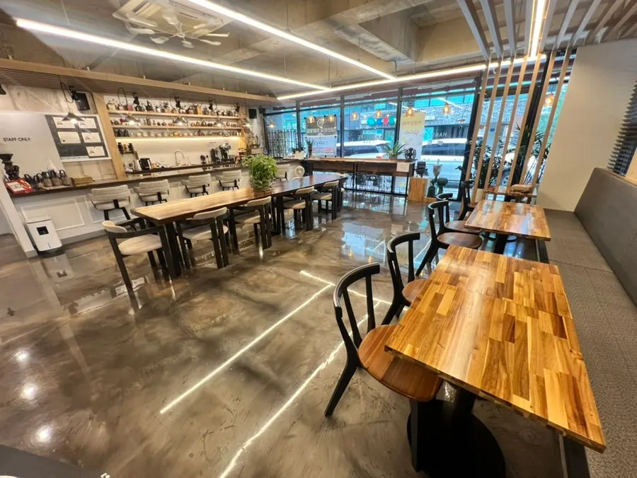Café interior with floor-to-ceiling windows and wood-toned tables