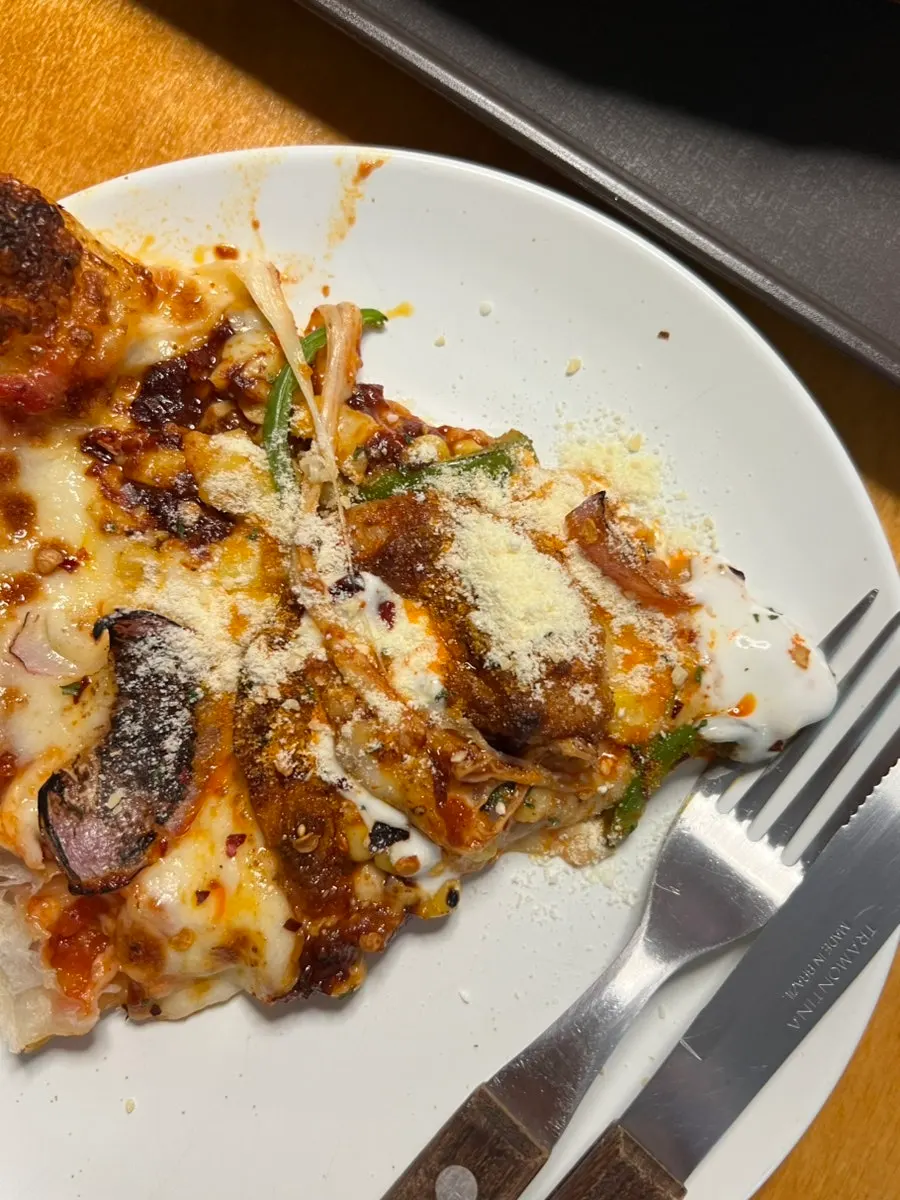 A slice of pizza sprinkled with cheese powder