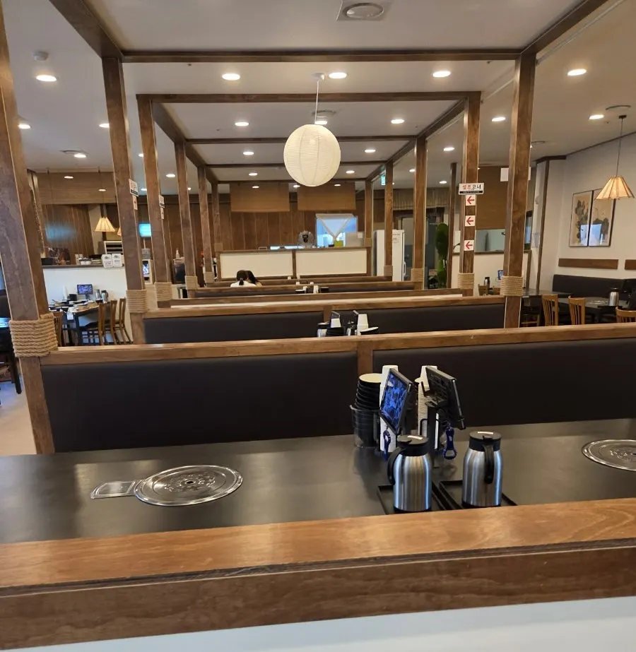 Jeju Badang's interior with wood-tone decor and stone wall