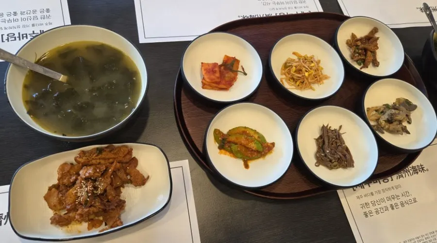 Kimchi, seasoned vegetables, and japchae at Jeju Badang's self-serve bar